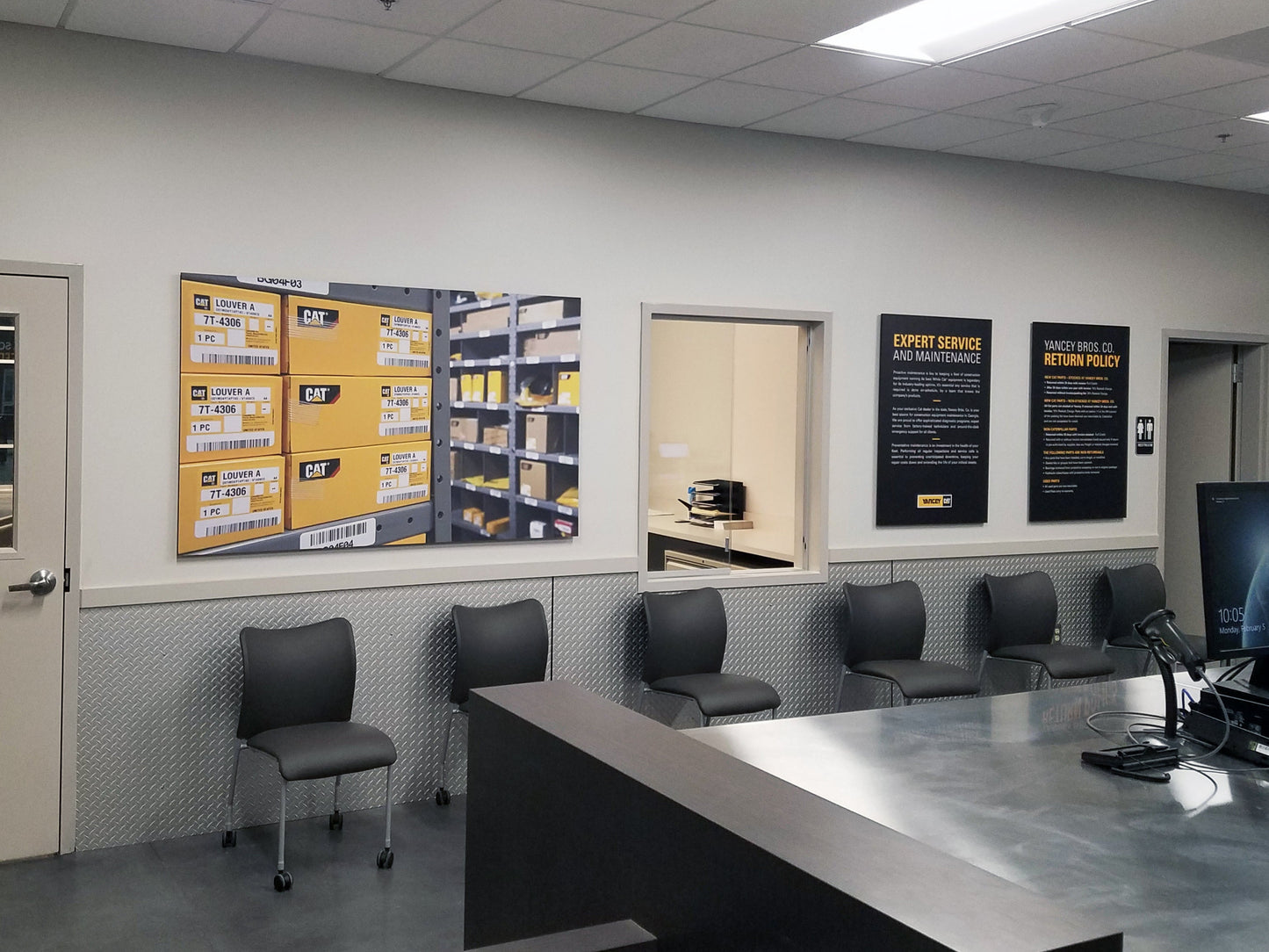 Waiting area with chairs, a counter, and informational posters on the wall.